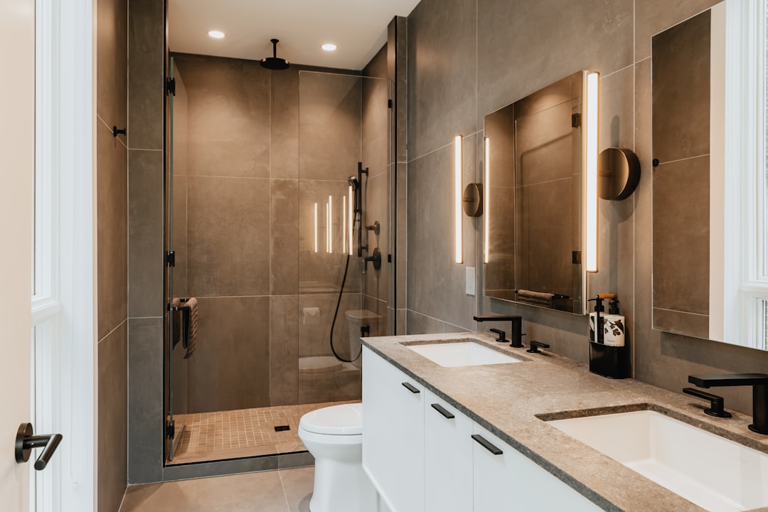 Beautiful quality bathroom renovation with new fixtures, custom tile work, elegant vanity cabinetry, and spa-like atmosphere