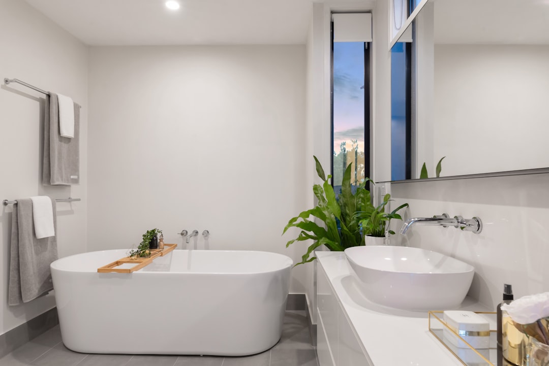Satisfied homeowner in beautifully renovated bathroom, complete remodel showing reliable quality work and happy customer