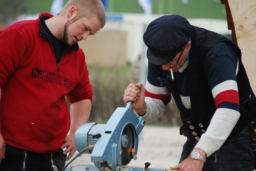 Two tradespeople working together with power tools on a cabinetry project